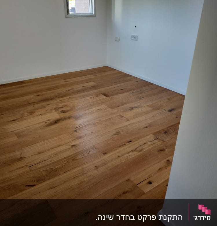 רצפת פרקט עץ בחדר ריק עם קירות לבנים